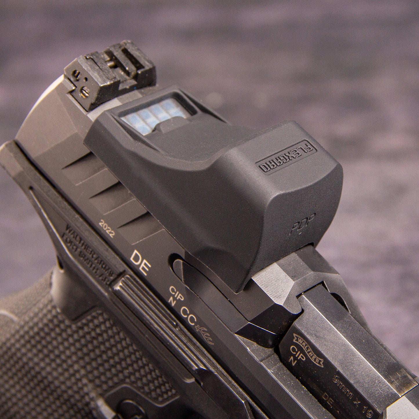 Close-up of a FlexGard Rubber Dust Cover for Holosun SCS PDP mounted on a dark metallic handgun, showing the sight's textured cover and the slide markings. [ads-hide]