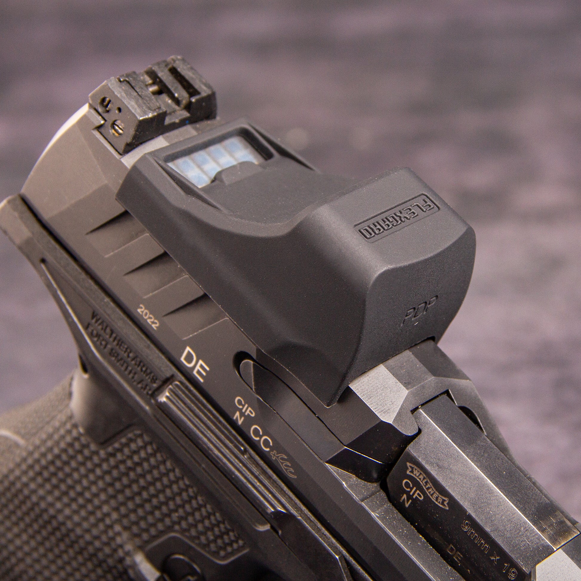 Close-up of a FlexGard Rubber Dust Cover for Holosun SCS PDP mounted on a dark metallic handgun, showing the sight's textured cover and the slide markings. [ads-hide]