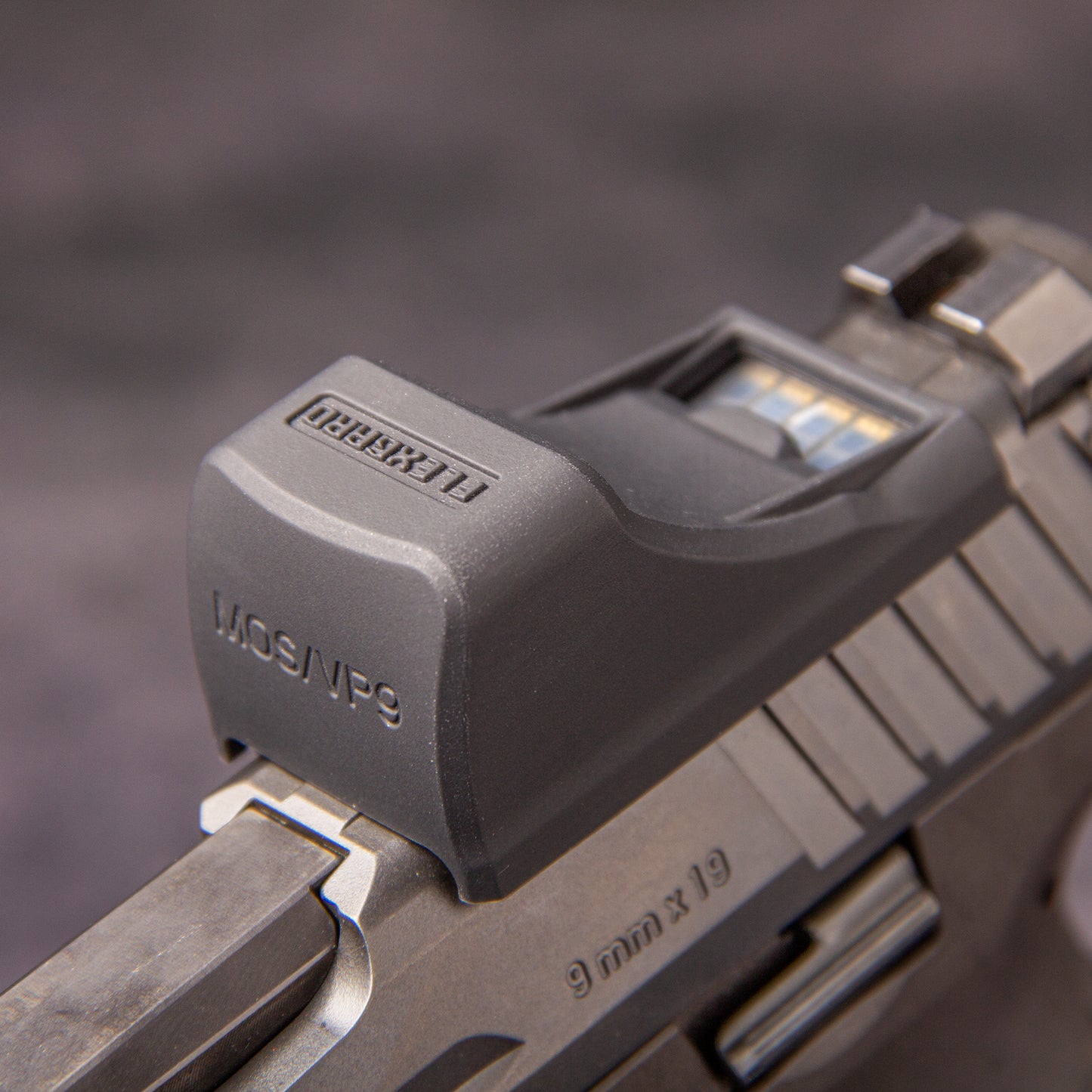 Close-up of a FlexGard Rubber Dust Cover for Holosun SCS VP9 mounted on a handgun [ads-hide]