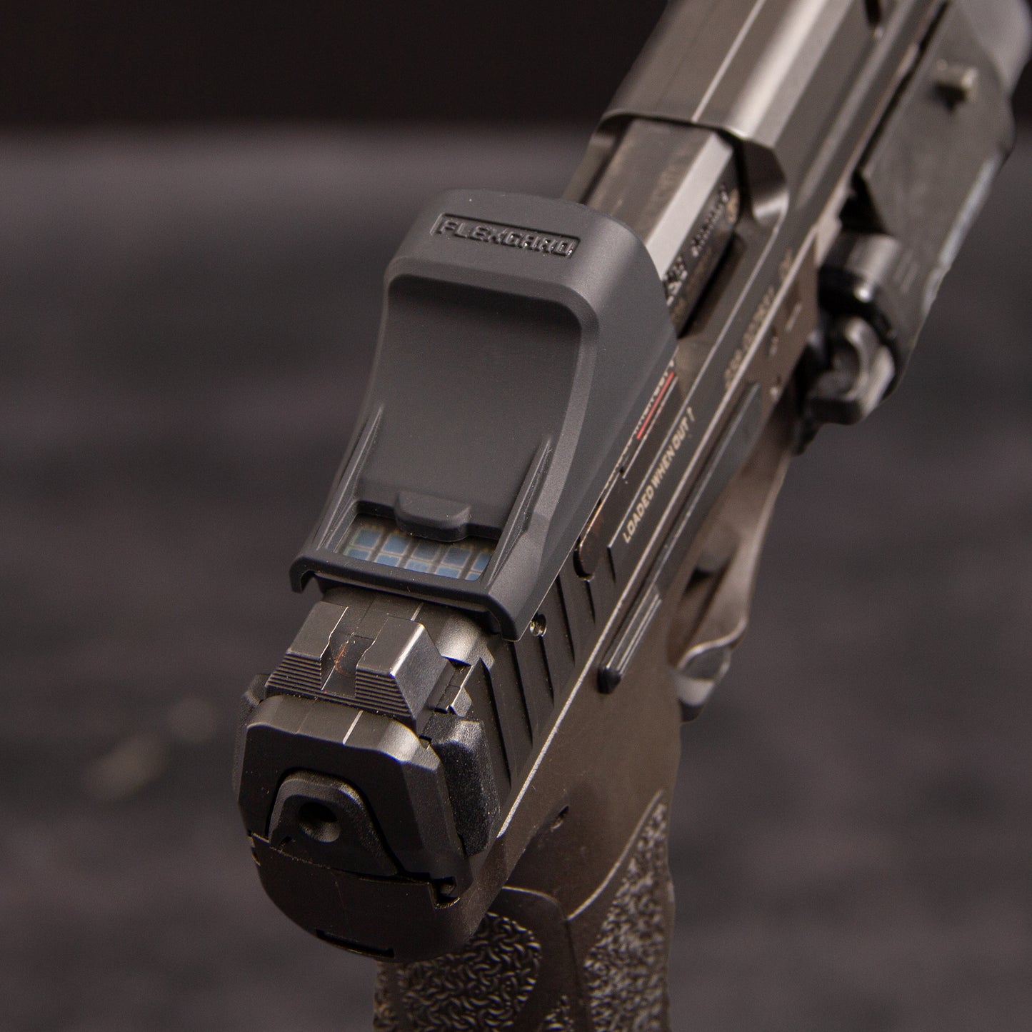 Close-up of a FlexGard Rubber Dust Cover for Holosun SCS VP9 mounted on a handgun [ads-hide]