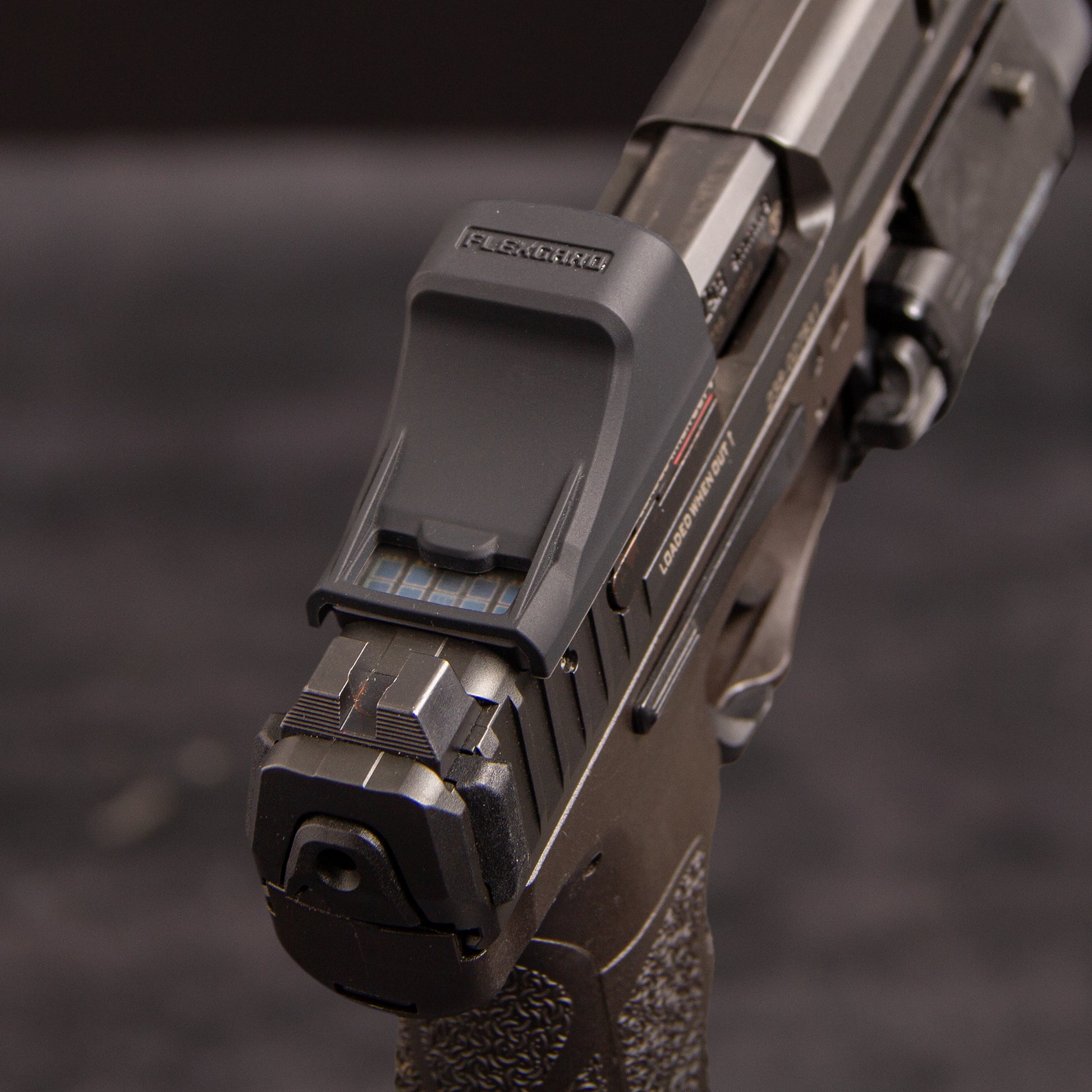 Close-up of a FlexGard Rubber Dust Cover for Holosun SCS VP9 mounted on a handgun [ads-hide]
