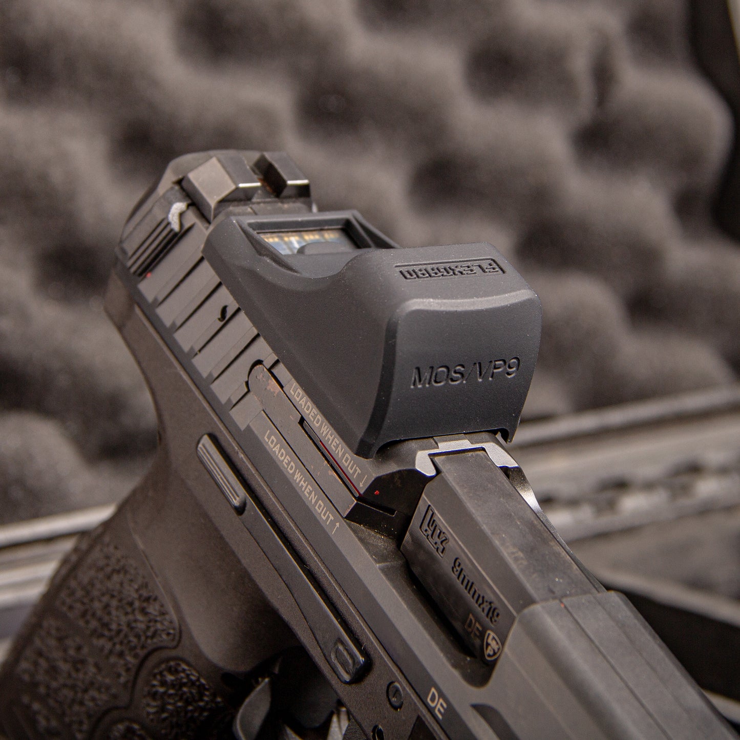 Close-up of a FlexGard Rubber Dust Cover for Holosun SCS VP9 mounted on a handgun [ads-hide]