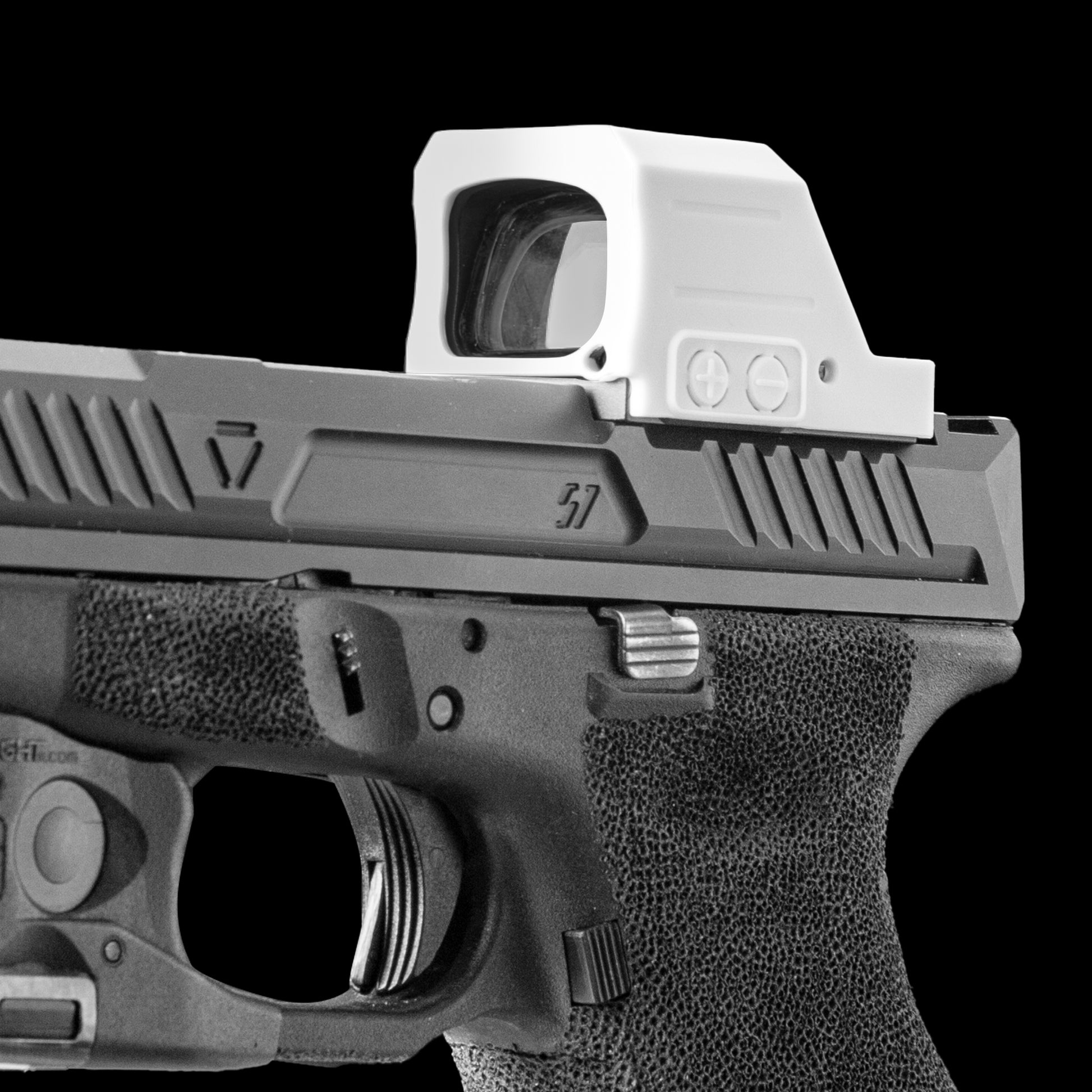 A close-up studio shot of a handgun with a white opticgard cover for holosun 507c X3 against a solid black background. [ads-hide]