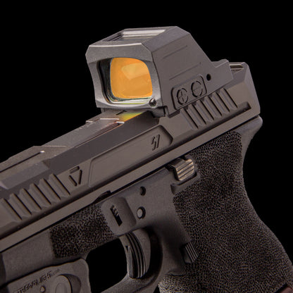 Close-up of a black semi-automatic handgun with a black opticgard cover for holosun 507c x3 shown against a solid black background. [ads-hide]