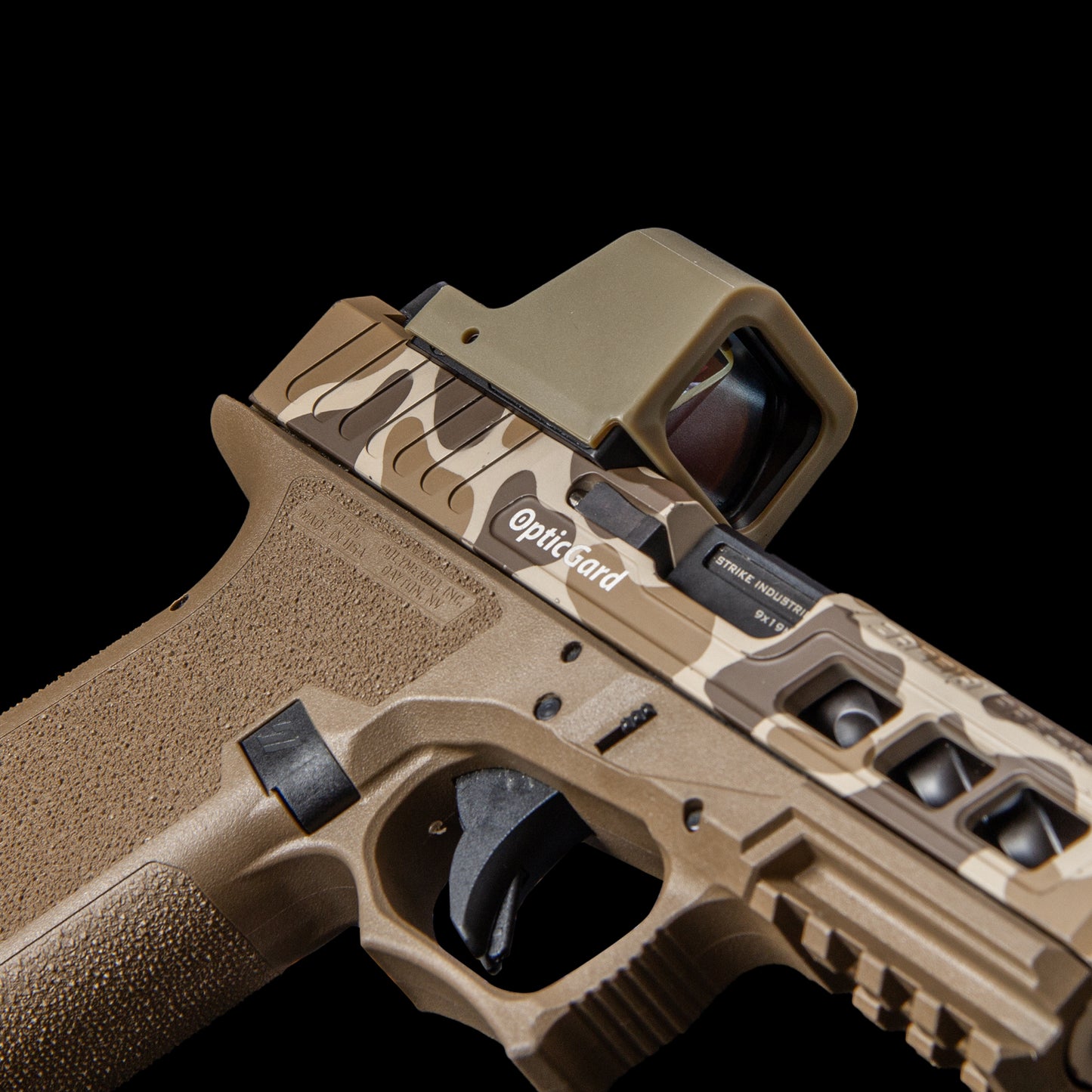 A close-up studio shot of a tactical pistol in a desert tan camouflage finish, featuring a  Opticgard Cover against a solid black background. [ads-hide]