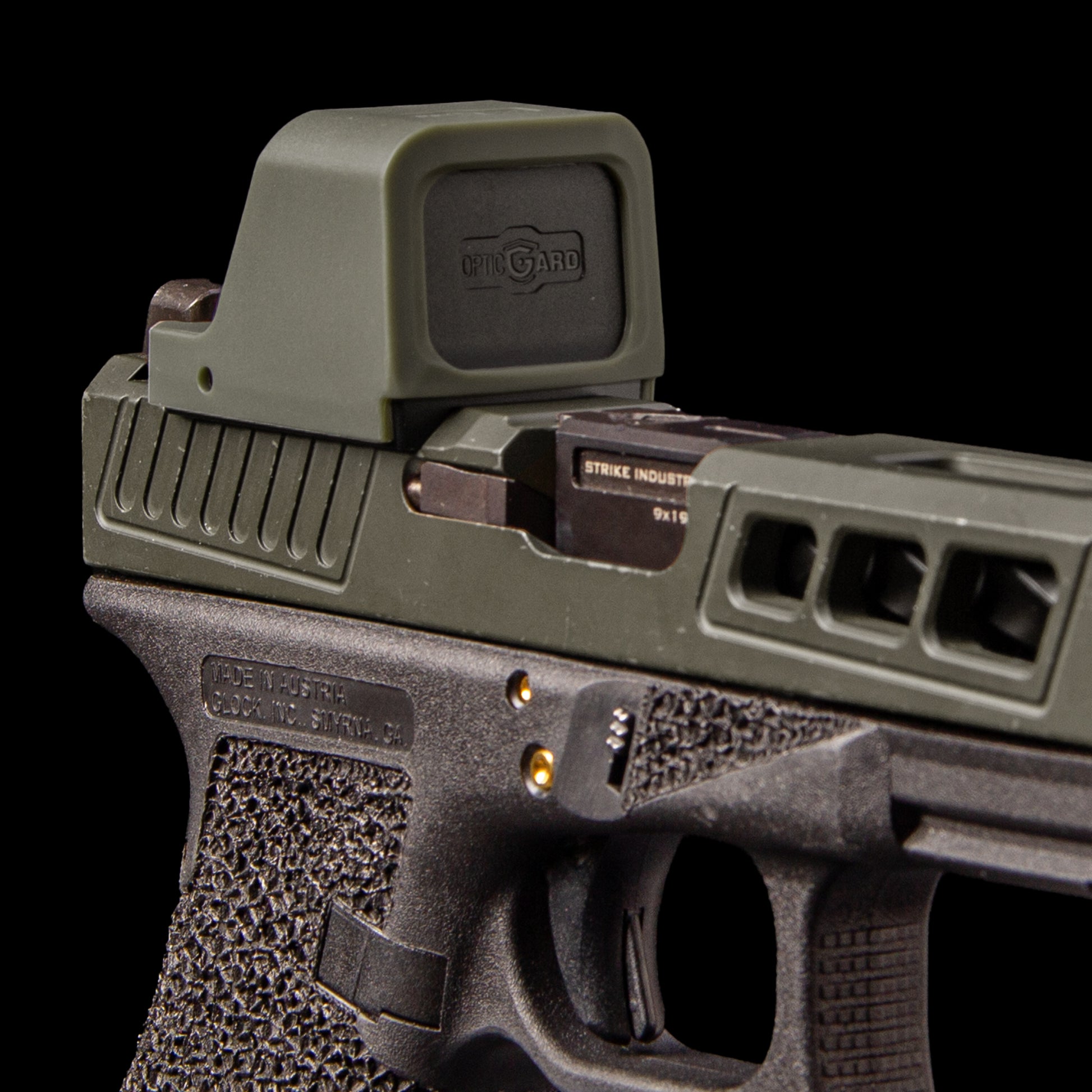 Close-up of a semi-automatic handgun with an OpticGard Cover , a black foregrip, and a visible Strike Industries logo on the slide, set against a solid black background
[ads-hide]